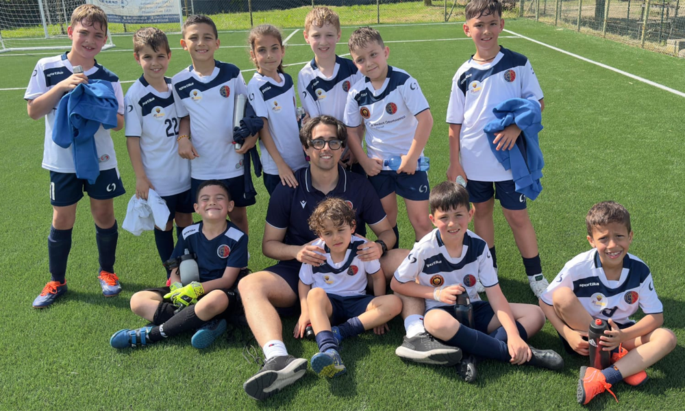Giovani calciatori della scuola calcio La Pelota ascoltano assieme al loro allenatore
