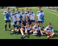 Giovani calciatori della scuola calcio La Pelota ascoltano assieme al loro allenatore