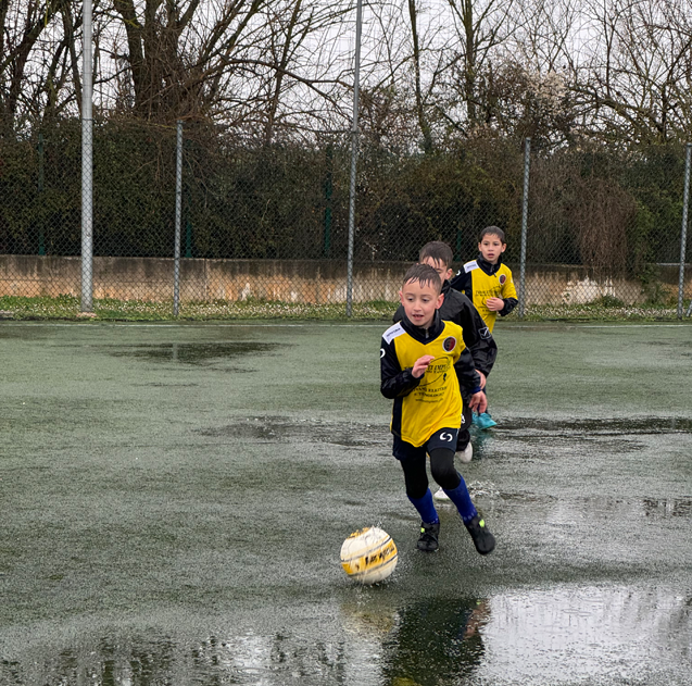 Bambini Bambini della scuola calcio La Pelota gioccano a calcio in inverno